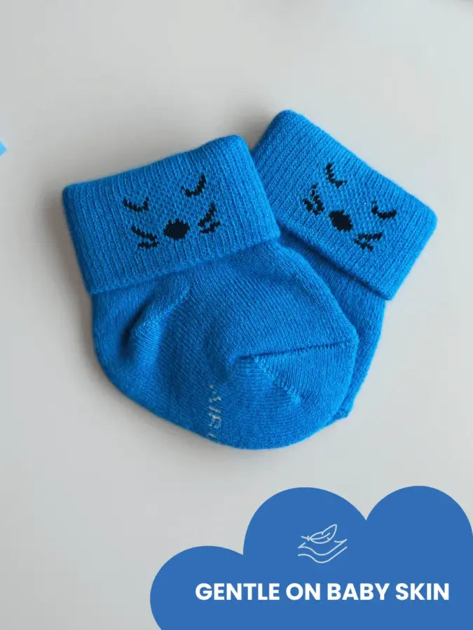 Air Garb baby combo socks for infants 0-1 years; a 6-pair collection arranged in a circle featuring animal faces like pink owl, brown giraffe, and white dog, alongside kitten-themed socks in purple, lime green, and blue.